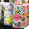 A set of home fragrances in decorative, floral, cylindrical containers