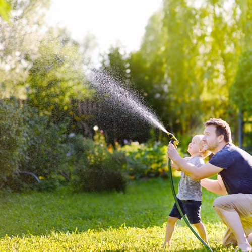 father and son watering plants